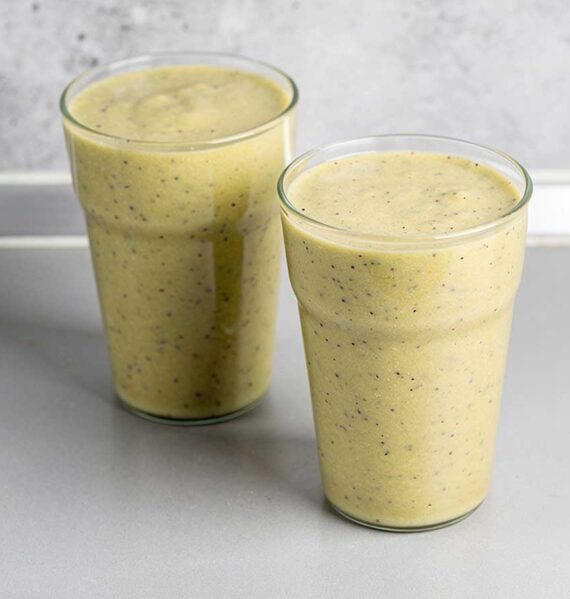 2 glazen met appel banaan kiwi sinaasappel smoothie.