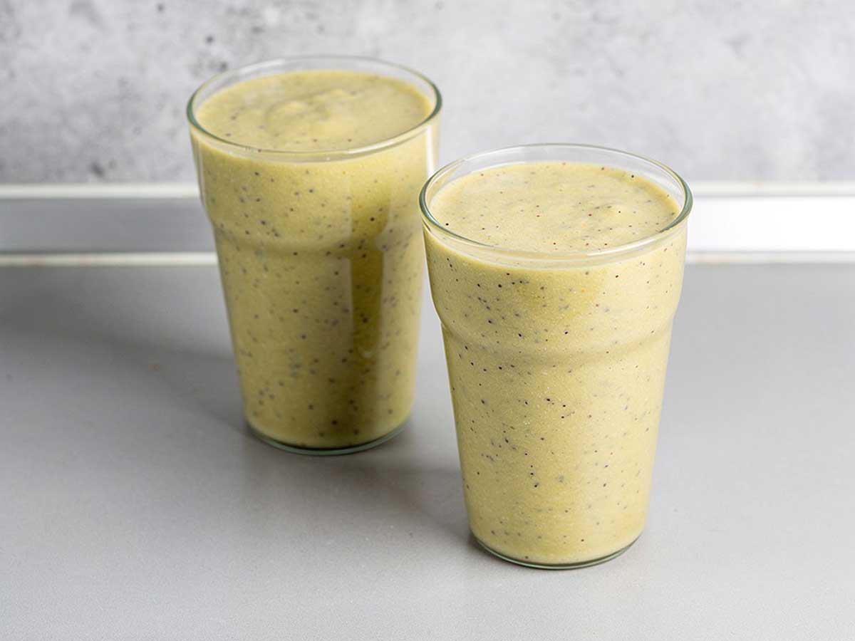 2 glazen met appel, banaan, kiwi & sinaasappelsmoothie.