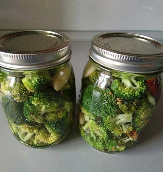 2 inmaakpotten met ingemaakte en geweckte broccoli.