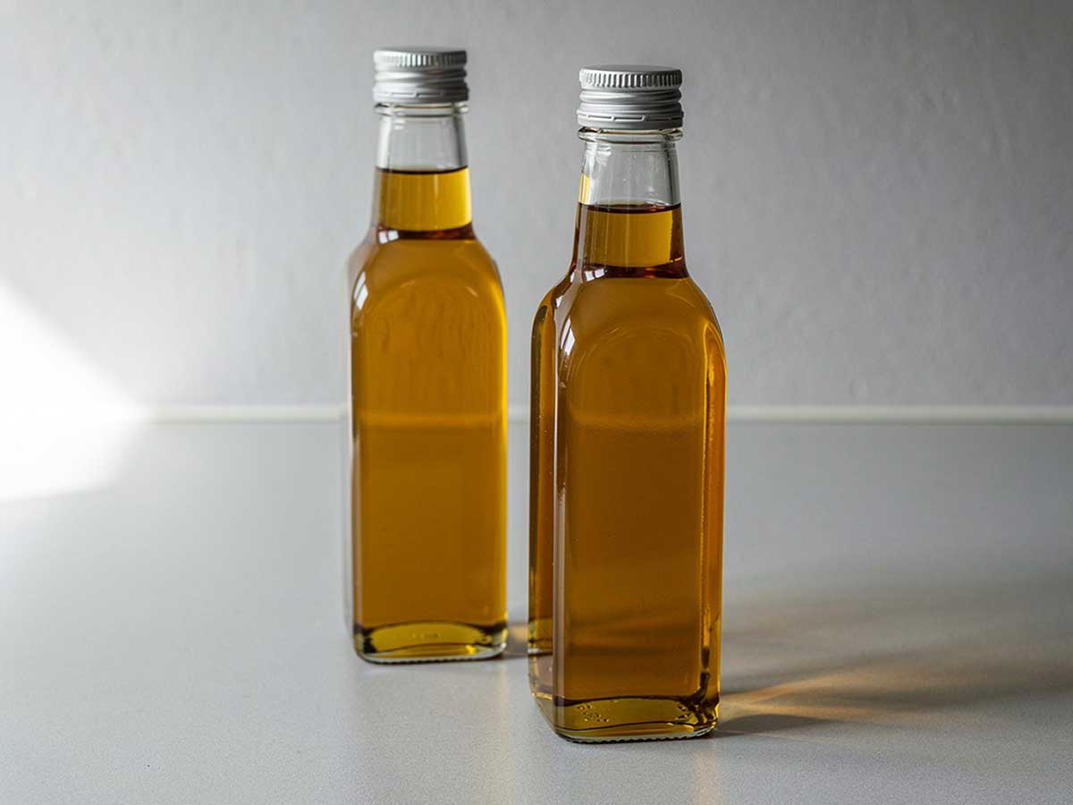 2 flesjes gefilterde hazelnootolie die in de koelkast bewaard worden.