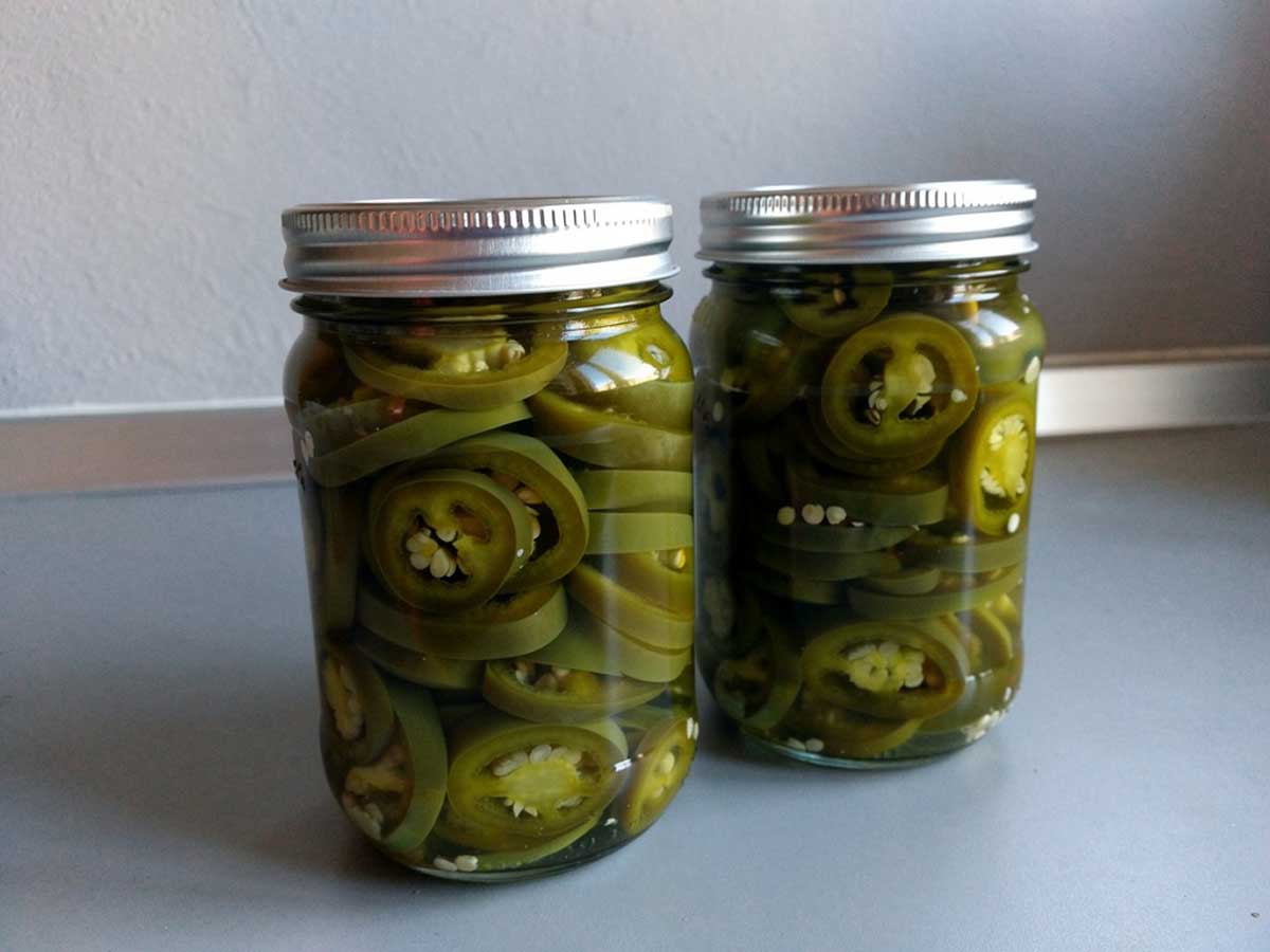 2 inmaakpotten met ingemaakt ringen Jalapeñ, op een zuur.