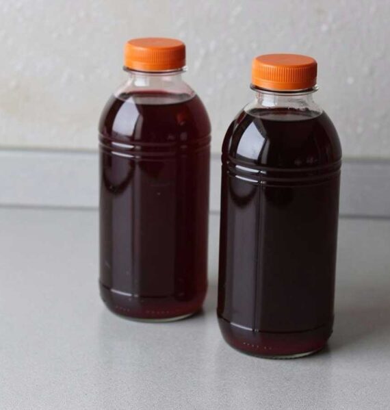 2 plastic flessen met daarin zelfgemaakt vlierbessensap.