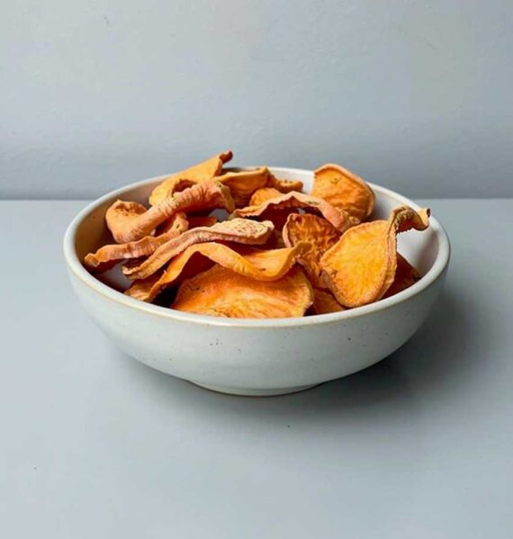Een schaaltje met daarin gedrogode plakjes zoete aardappel.
