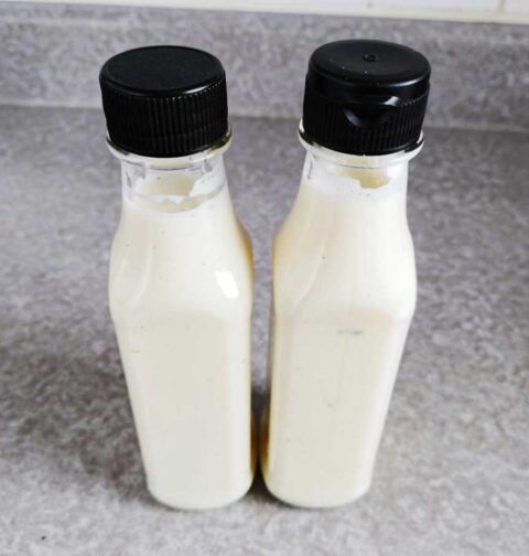 2 flesjes met daarin zelfgemaakte knoflookdressing.