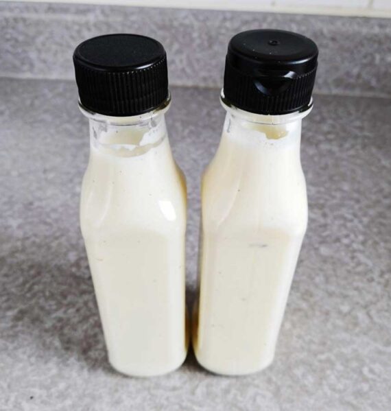 2 flesjes met daarin zelfgemaakte knoflookdressing.