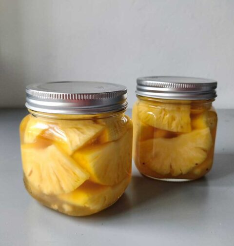 2 inmaakpotten met ingemaakt ananas op een suikersiroop.