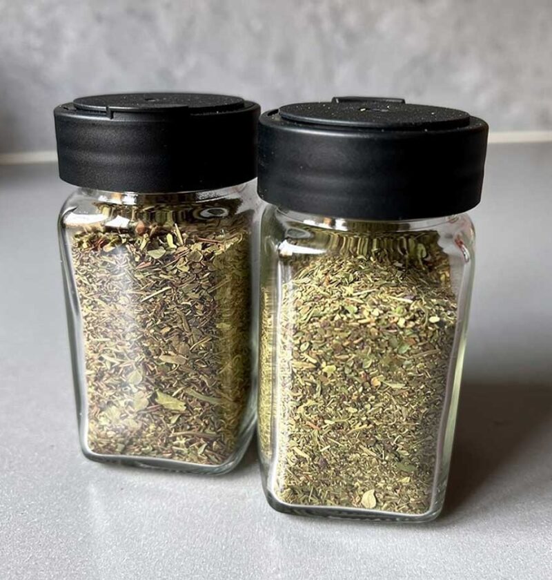 2 kruidenpotjes met gedroogde, klein gemaakte, basilicum.
