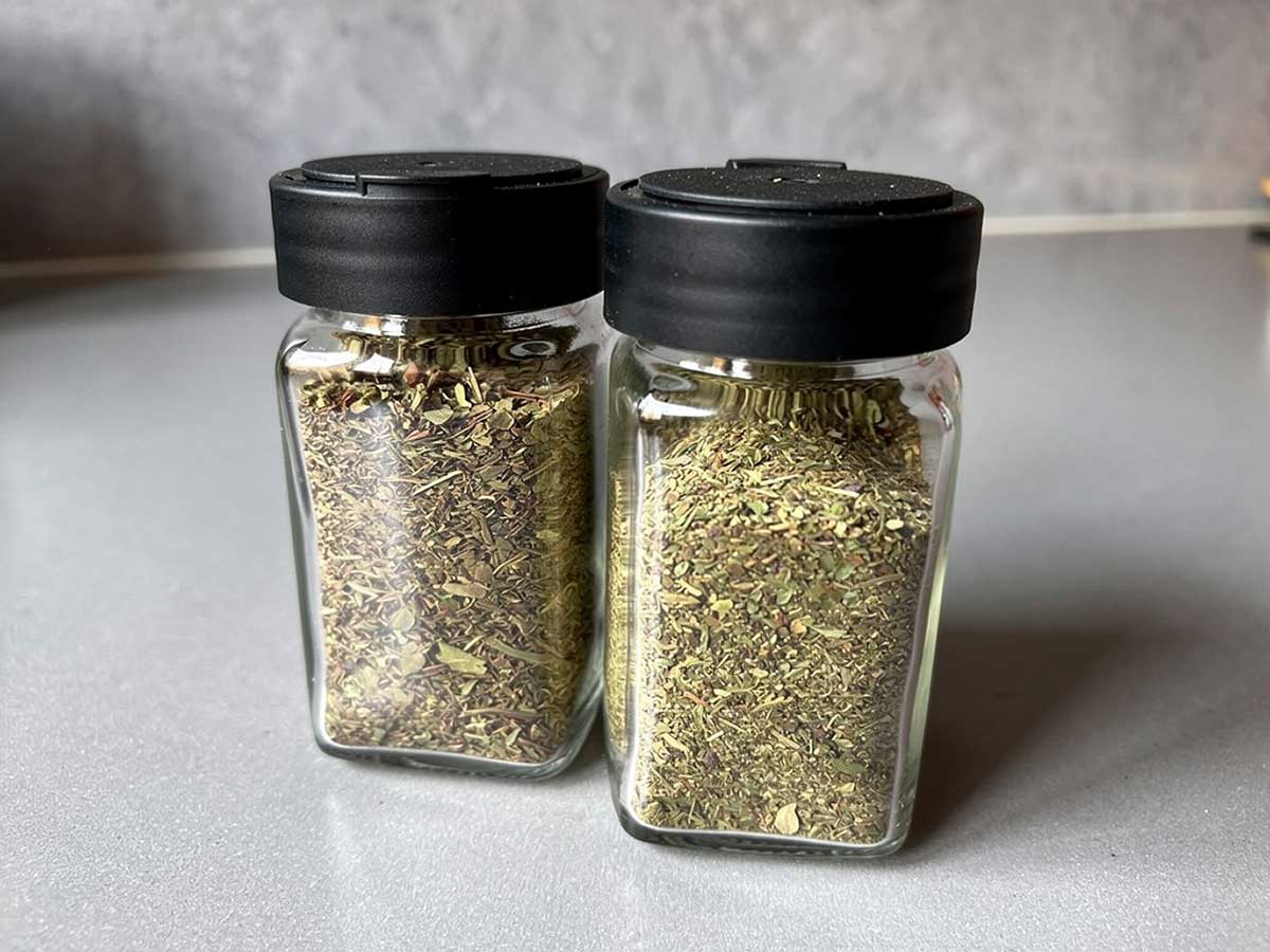 2 kruidenpotjes met gedroogde, klein gemaakte, basilicum.
