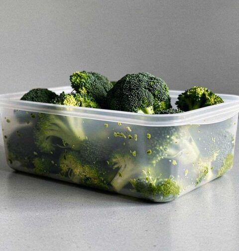 Een diepvriesbakje met daarin geblancheerde roosjes broccoli.