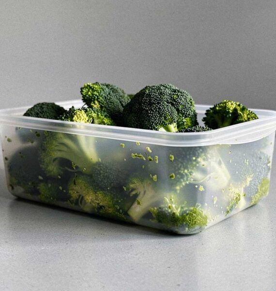Een diepvriesbakje met daarin geblancheerde roosjes broccoli.