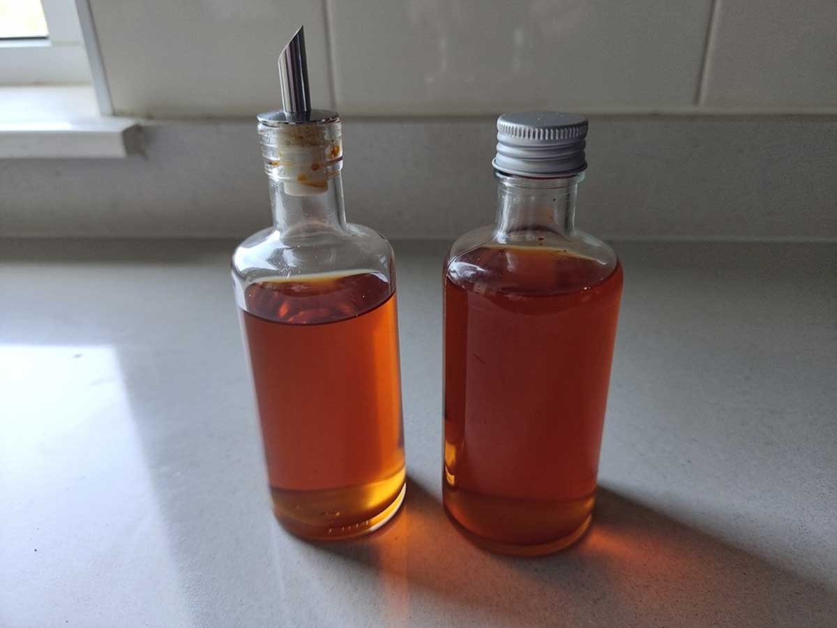 2 flesjes met chiliolie, waarvan er 1 met schenktuit.
