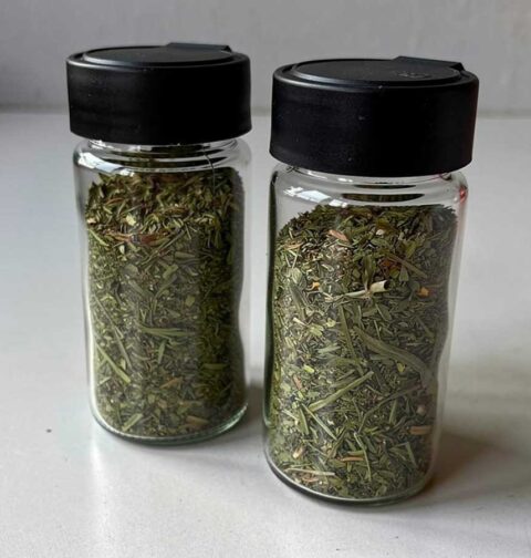 2 kruidenpotjes, gedeeltelijk gevuld met gedroogde dragon.