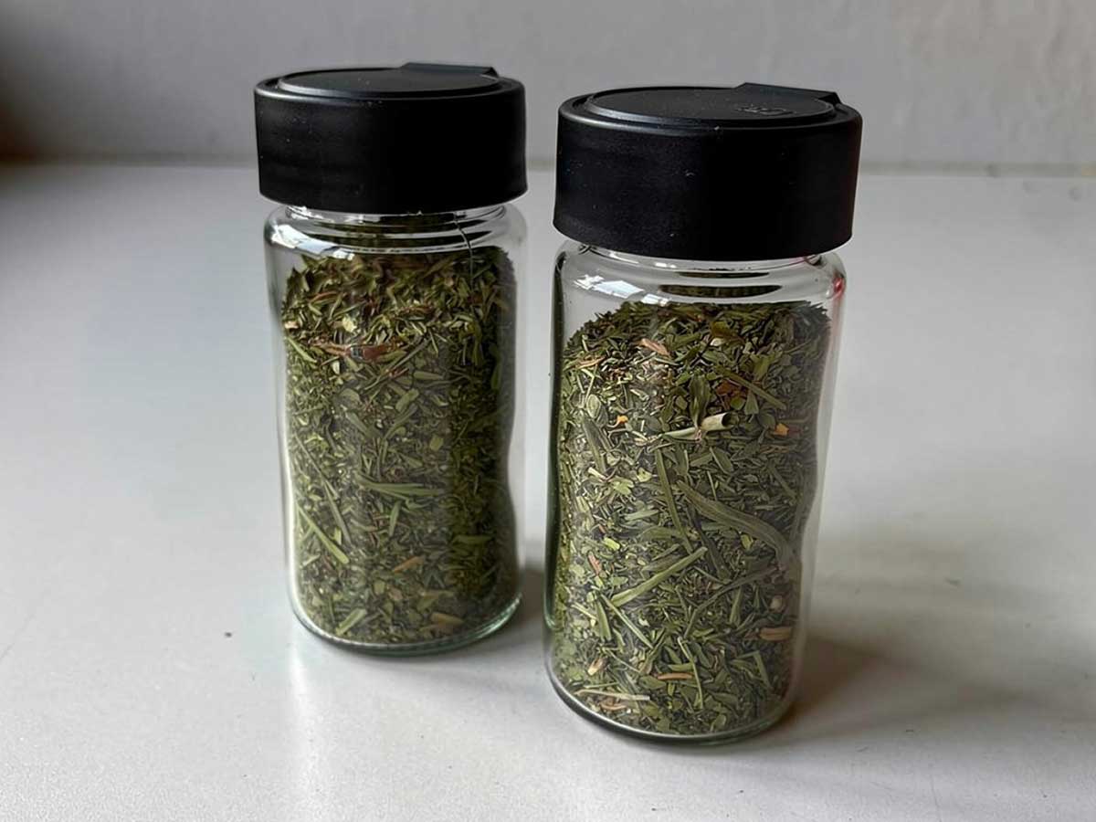 2 kruidenpotjes, gedeeltelijk gevuld met gedroogde dragon.