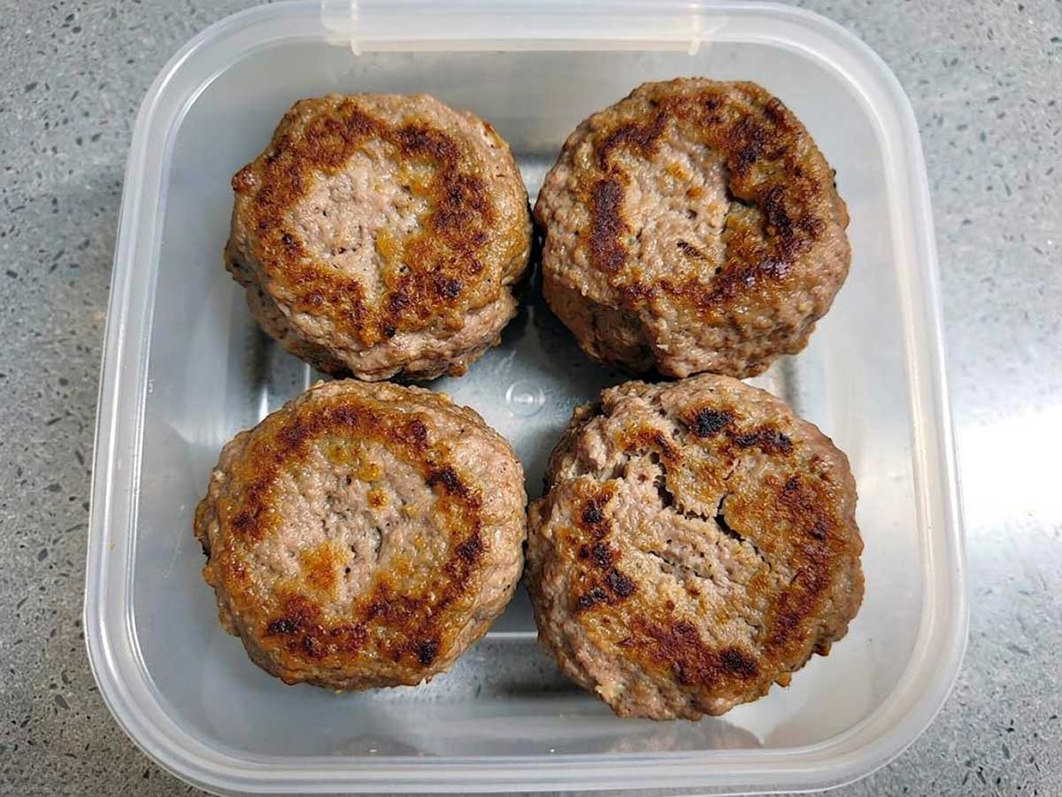 4 gebakken gehaktballen in een vierkant diepvriesbakje.