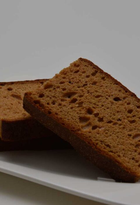 3 plakken ontbijtkoek liggen op een wit schaaltje, klaar om in te vriezen.