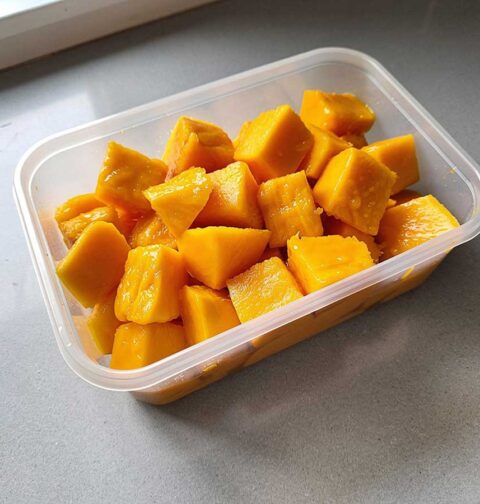 Een diepvriesbak gevuld met blokjes mango, om in te vriezen.