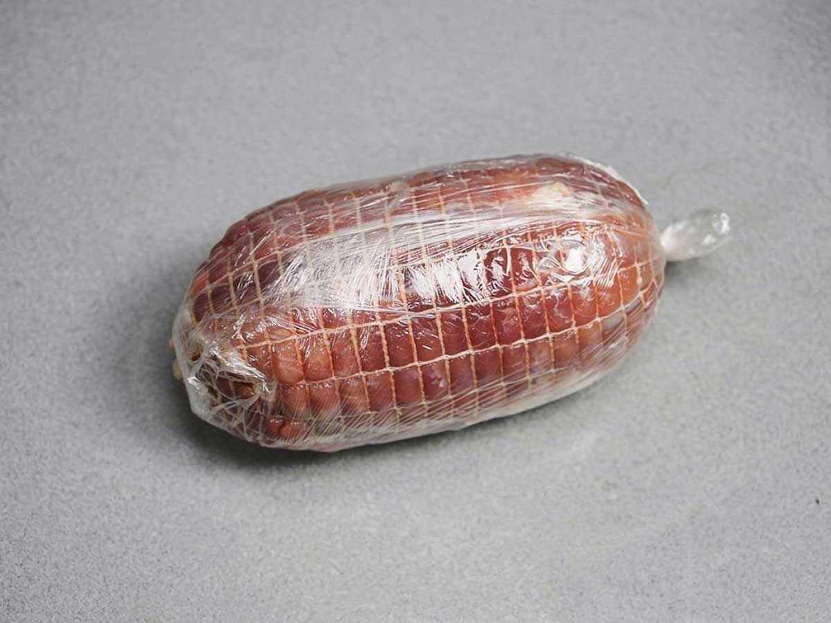 Een in vershoudfolie ingepakte varkensrollade. Nog een diepvrieszak er omheen en dan invriezen.