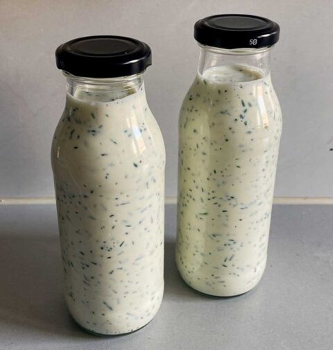 2 kleine flesjes met zelfgemaakte yoghurt-kruidendressing.