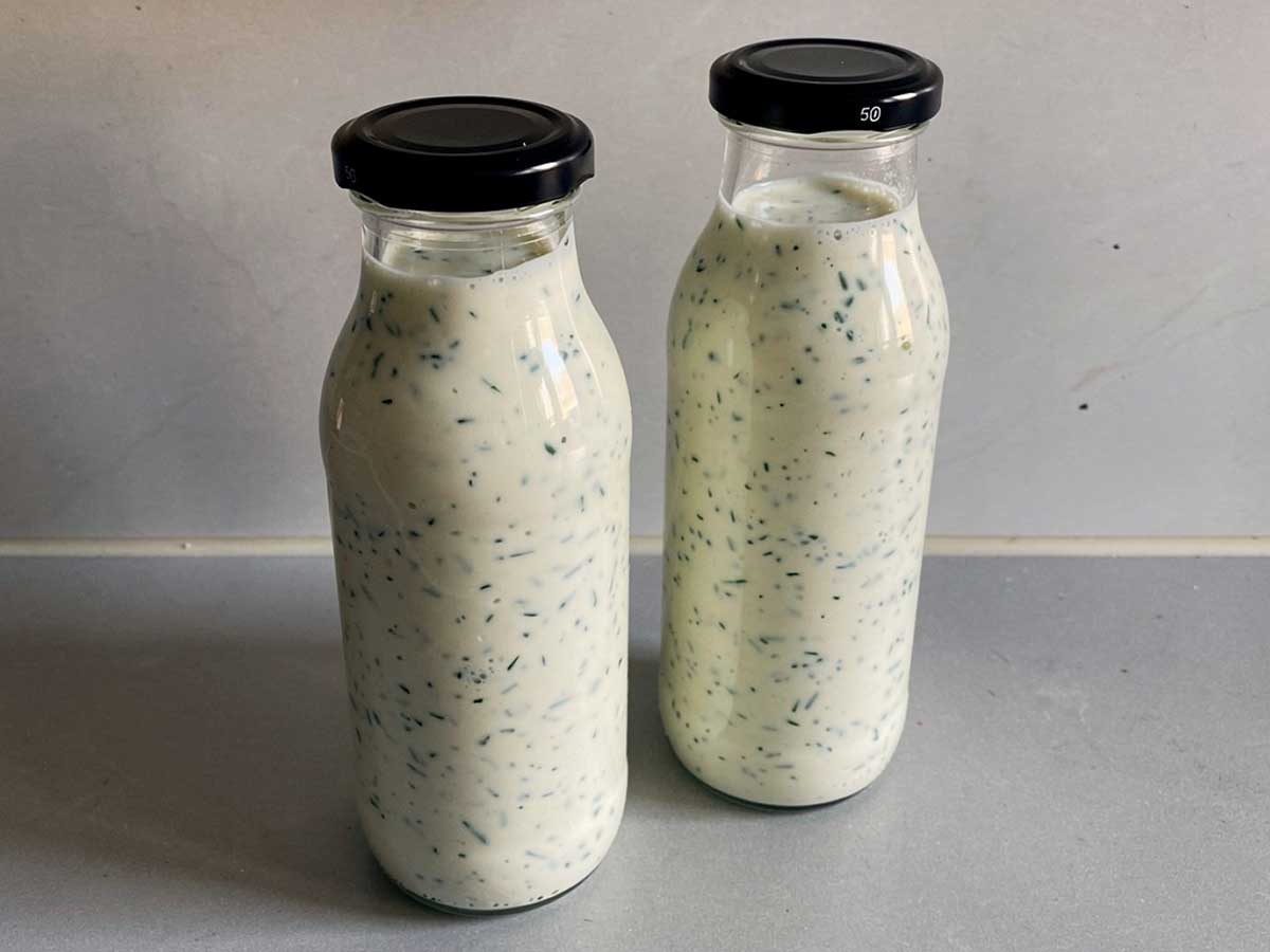 2 kleine flesjes met zelfgemaakte yoghurt-kruidendressing.