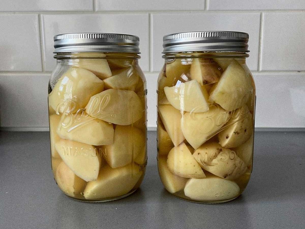 2 grote weckpotten met geweckte aardappelen.