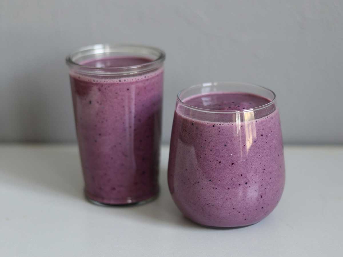 2 verschillende glazen met Banaan-blauwe bessen smoothie.