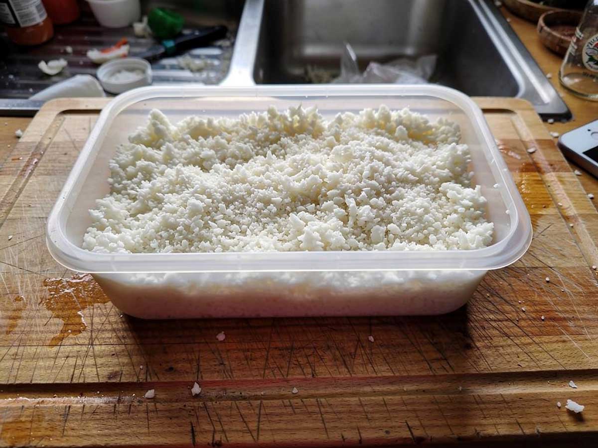 Een plastic bakje met een overschot aan bloemkoolrijst.
