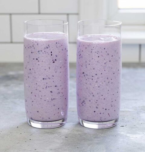 2 glazen met zelfgemaakte bosbessen milkshake.