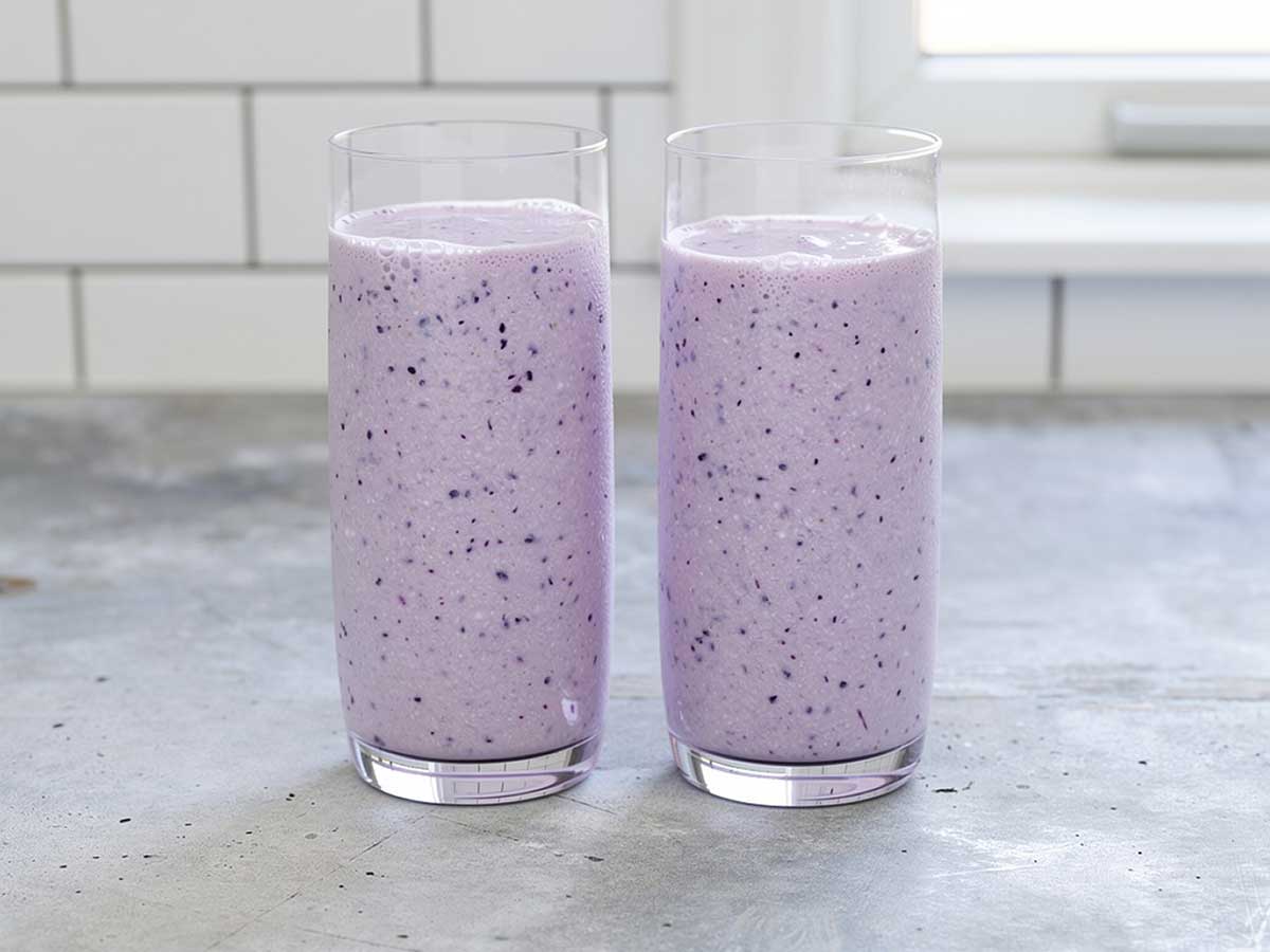2 glazen met zelfgemaakte bosbessen milkshake.