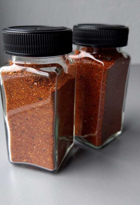 Twee kruidenpotjes met een chili con carne kruidenmix.