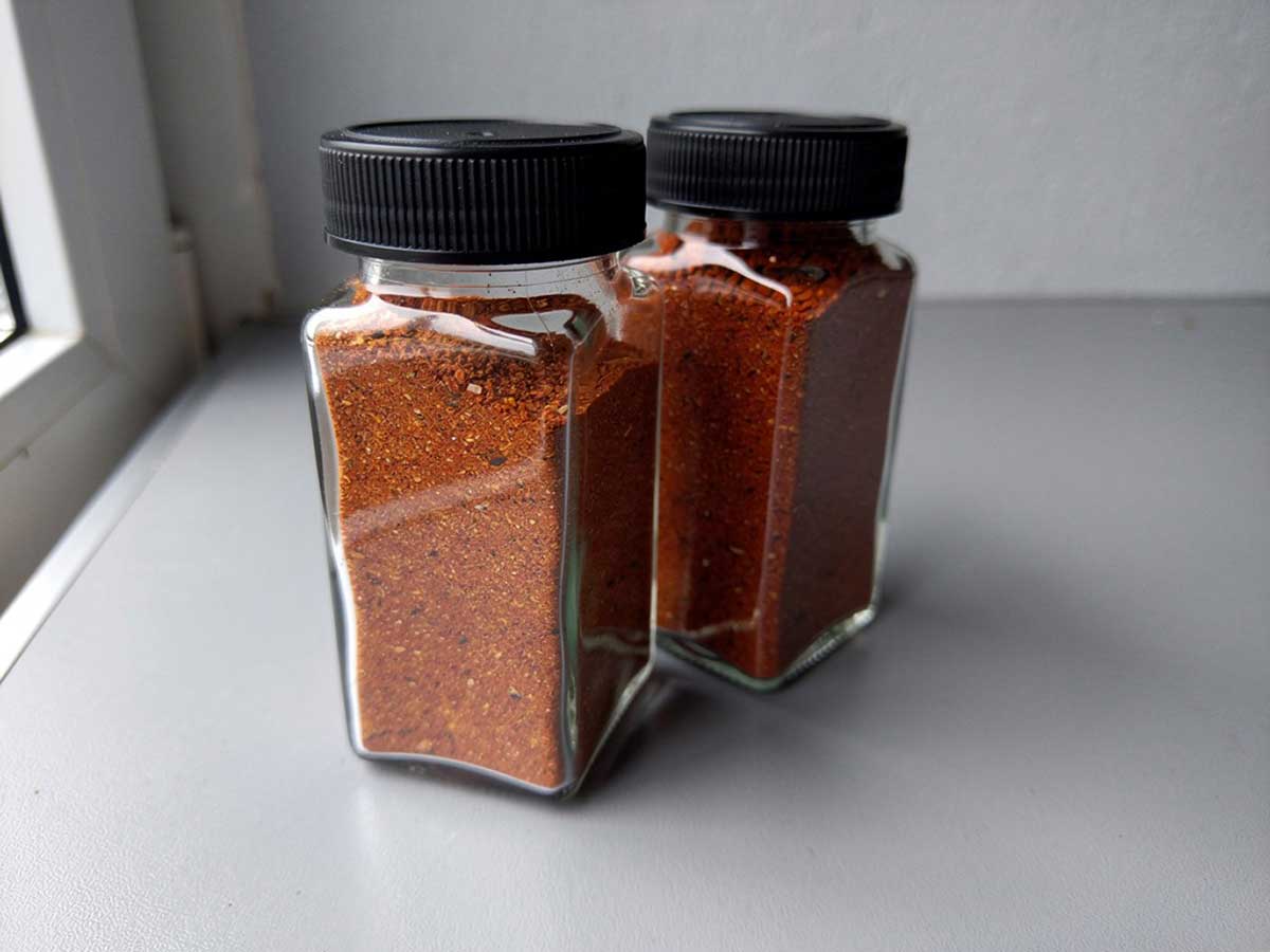 Twee kruidenpotjes met een chili con carne kruidenmix.