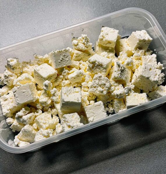 Een diepvriesbak met stukjes en verkruimelde feta.