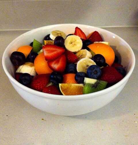 Een wit schaaltje met een zelfgemaakte fruitsalade.