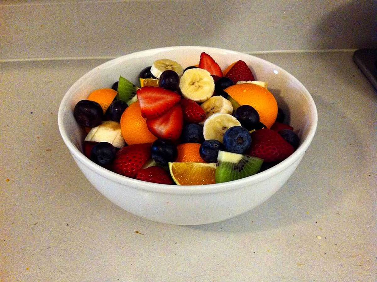 Een wit schaaltje met een zelfgemaakte fruitsalade.