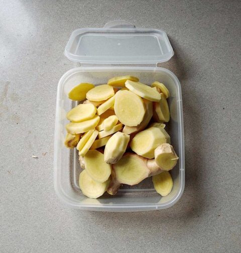 Een dievriesbakje met geschillde stukken en plakjes gember om in te vriezen.