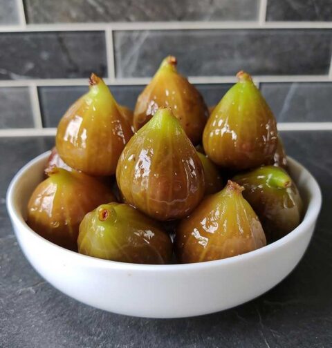 Een wit schaaltje met gekonfijte groene vijgen.