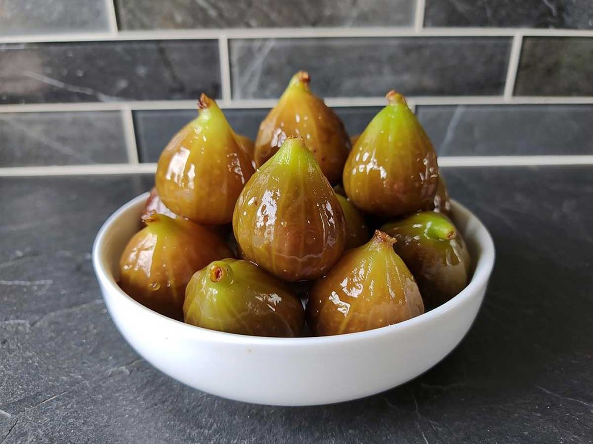 Een wit schaaltje met gekonfijte groene vijgen.