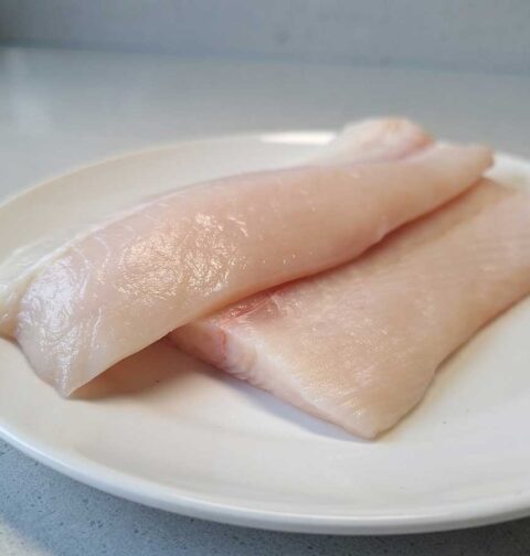 2 heilbotfilets op een wit bord, klaar om op de juiste manier bewaard te worden.