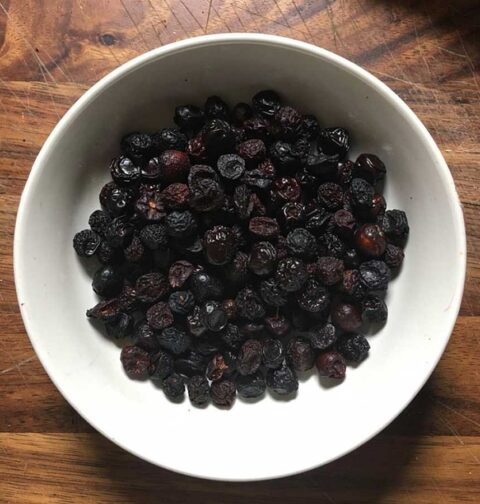 Een wit schaaltje met gedroogde kersen.