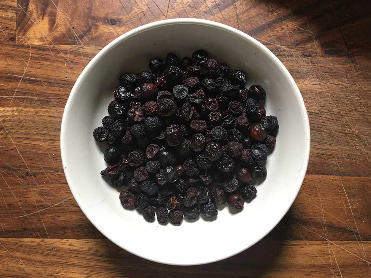 Een wit schaaltje met gedroogde kersen.