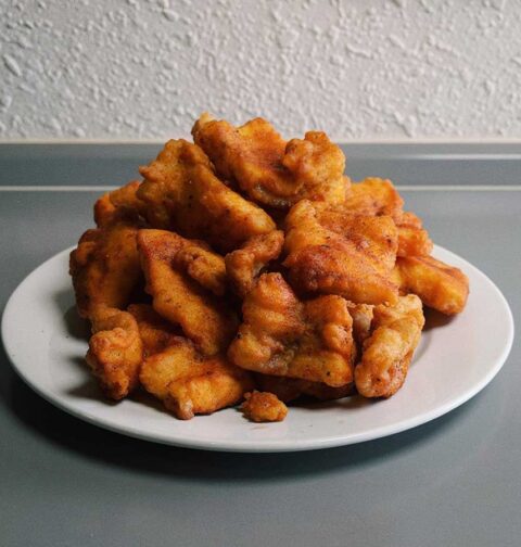Een wit bord met overgebleven kibbeling.