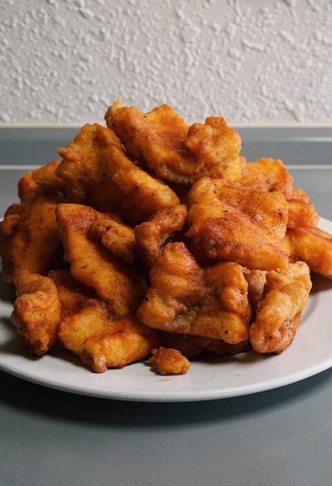 Een wit bord met overgebleven kibbeling.