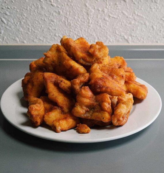 Een wit bord met overgebleven kibbeling.