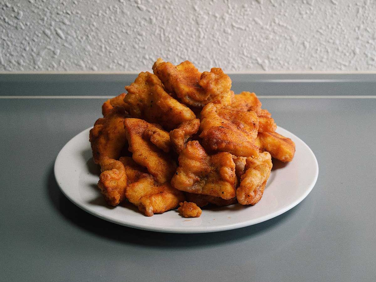 Een wit bord met overgebleven kibbeling.