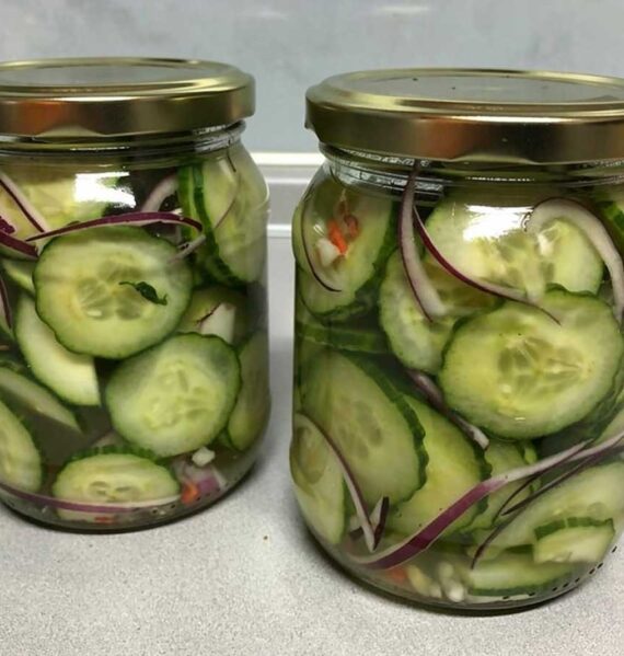 2 inmaakpotten gevuld met ingelgede kplakjes komkommer.