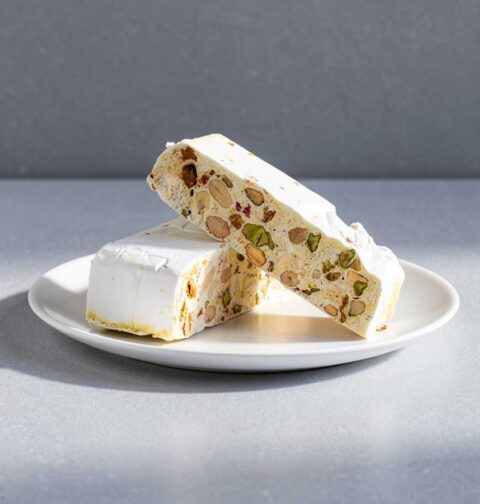 Twee grote stukken nougat op een wit bordje.