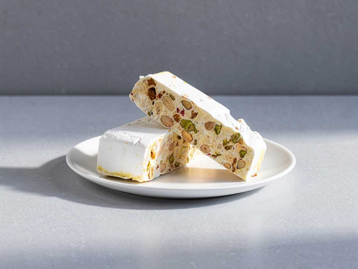 Twee grote stukken nougat op een wit bordje.