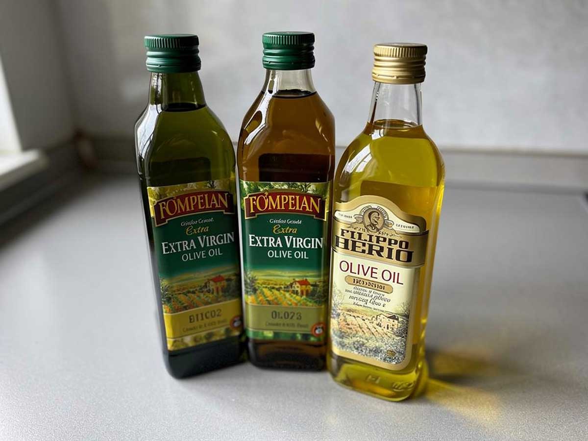 3 gesloten flessen olijfolie op een werkblad.