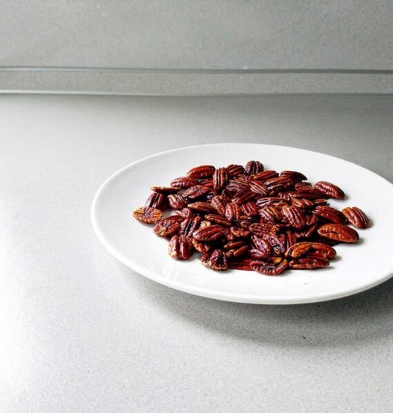 Een bordje met gekonfijte pecannoten.