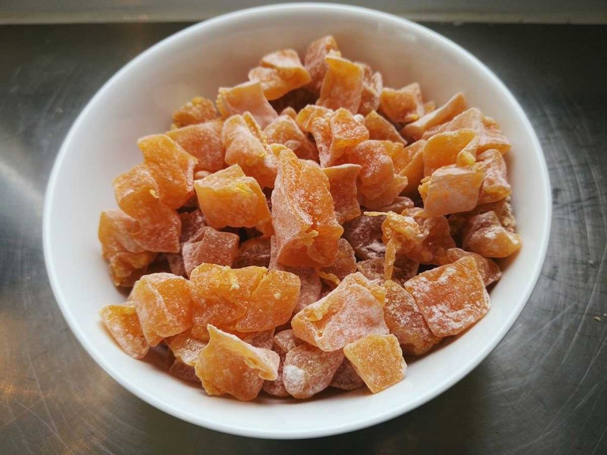 Een schaaltje met daarin stukjes gekonfijte pompoen.
