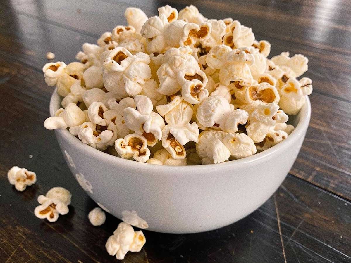 Een wit schaaltje gevuld met net gemaakte popcorn.